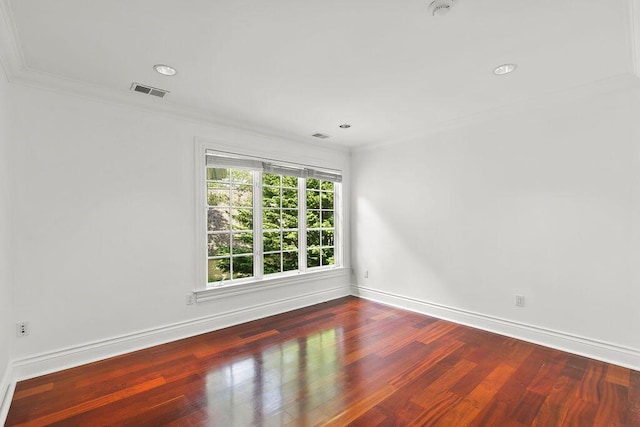 empty room with ornamental molding and hardwood / wood-style floors