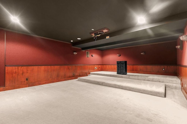 cinema featuring carpet, wooden walls, and crown molding