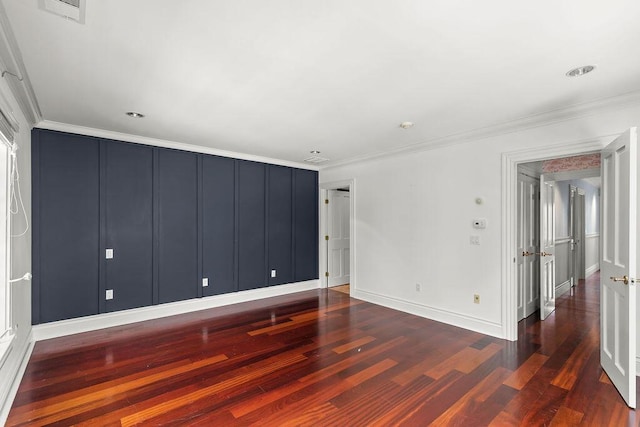 spare room featuring dark wood-type flooring and ornamental molding