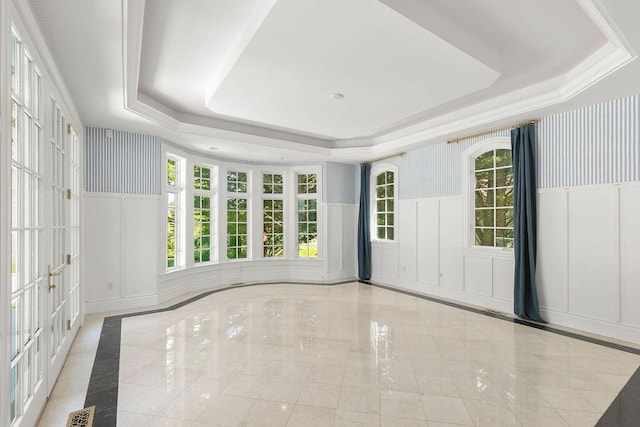 empty room with a raised ceiling and a healthy amount of sunlight