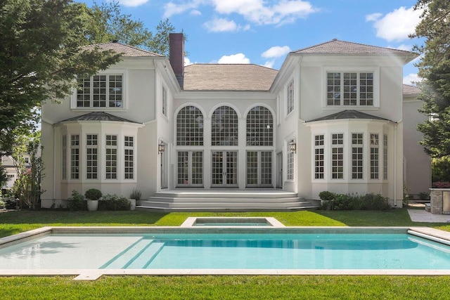 rear view of property featuring a lawn