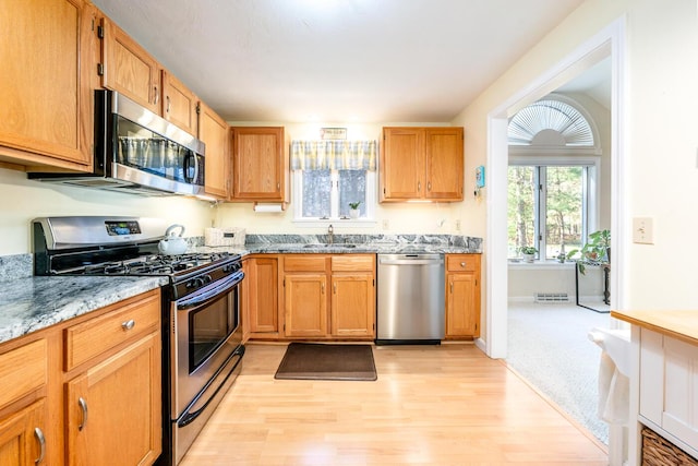 12 Kettle Ln, Mashpee, MA 02649 - kitchen with appliances with stainless steel finishes, light wood-style flooring, light stone counters, and a sink