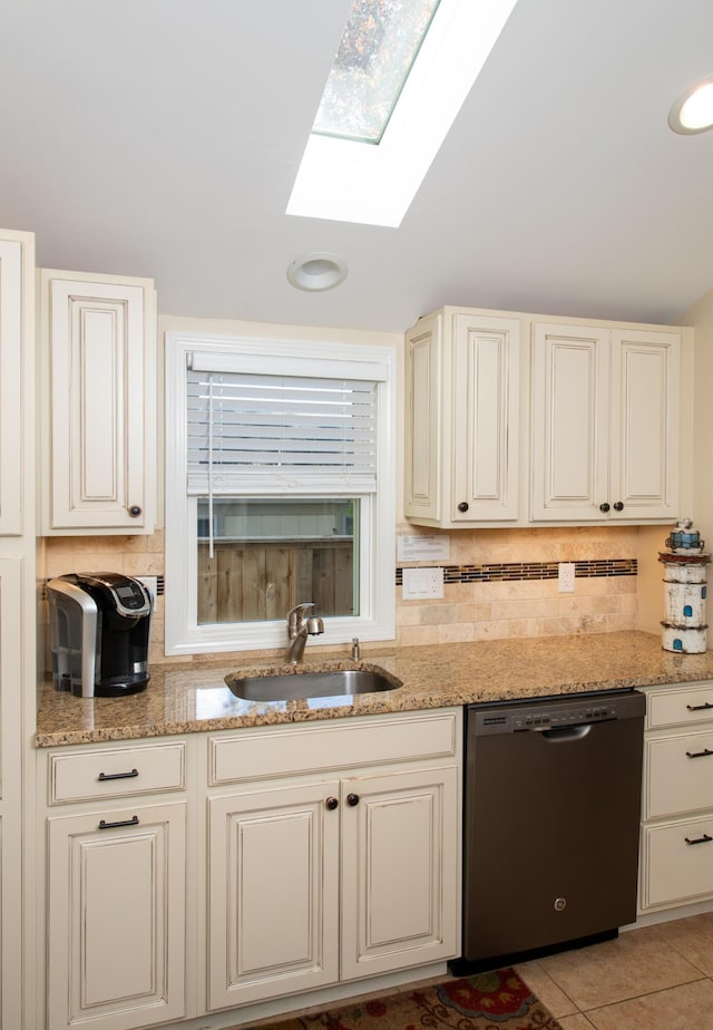 56 S Yarmouth Rd, Dennis, MA 02638 - kitchen featuring stainless steel dishwasher, a sink, a skylight, backsplash, and light stone countertops