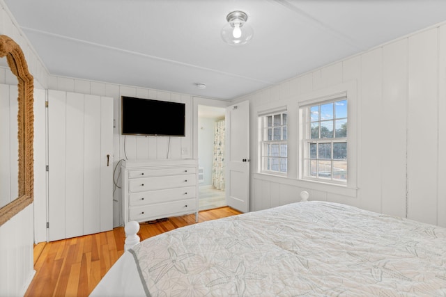 bedroom featuring ensuite bath and light wood-type flooring