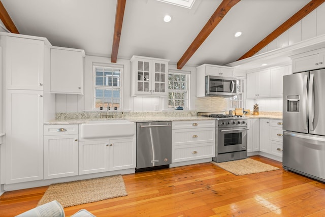 kitchen featuring sink, backsplash, white cabinetry, and stainless steel appliances