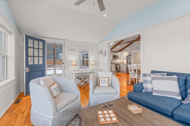 living room featuring lofted ceiling with beams, light hardwood / wood-style flooring, and ceiling fan