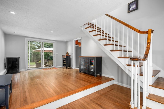 65 Hadrada Ln, Centerville, MA 02632 - unfurnished living room featuring stairs, wood finished floors, recessed lighting, and a textured ceiling