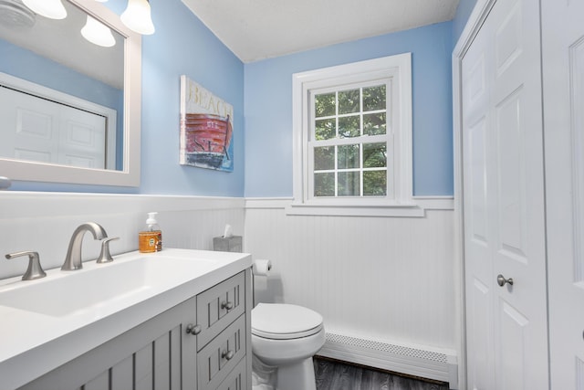 65 Hadrada Ln, Centerville, MA 02632 - bathroom featuring a baseboard radiator, a closet, a wainscoted wall, vanity, and wood finished floors