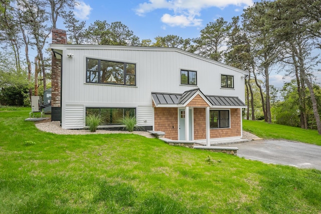 3 Laurie Ln, Harwich Port, MA 02646 - view of front facade with a standing seam roof, a chimney, a front yard, and metal roof