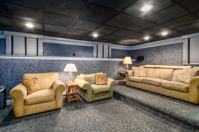 carpeted home theater room with crown molding and a drop ceiling