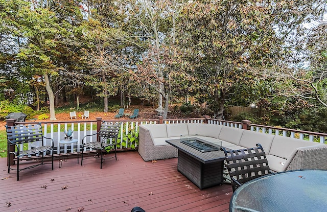 deck featuring an outdoor living space with a fire pit