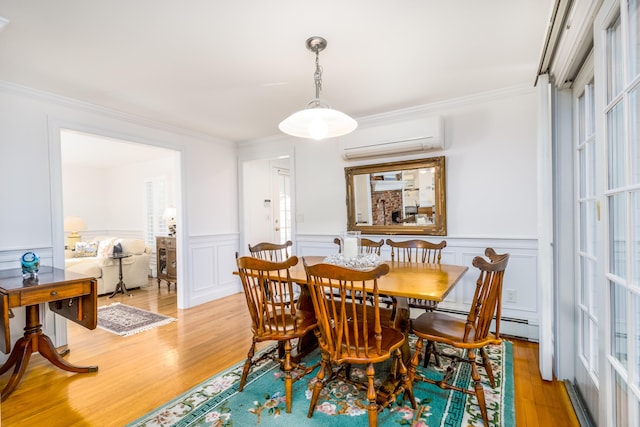 dining room with light wood-type flooring, an AC wall unit, and ornamental molding