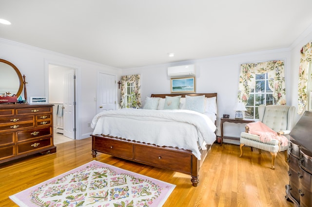 bedroom with a baseboard heating unit, crown molding, light hardwood / wood-style floors, and a wall unit AC