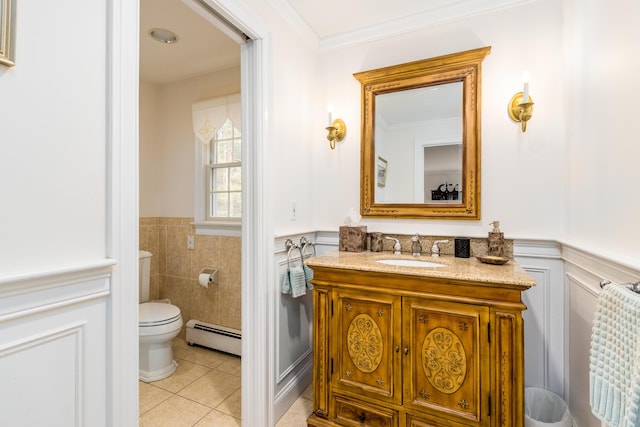 bathroom with toilet, crown molding, a baseboard heating unit, tile patterned flooring, and vanity