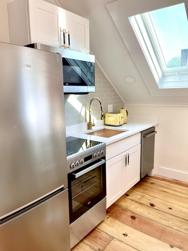 54 Commercial St Unit 3, 4, 5, 6, Provincetown, MA 02657 - kitchen with a sink, light wood finished floors, stainless steel appliances, tasteful backsplash, and a skylight