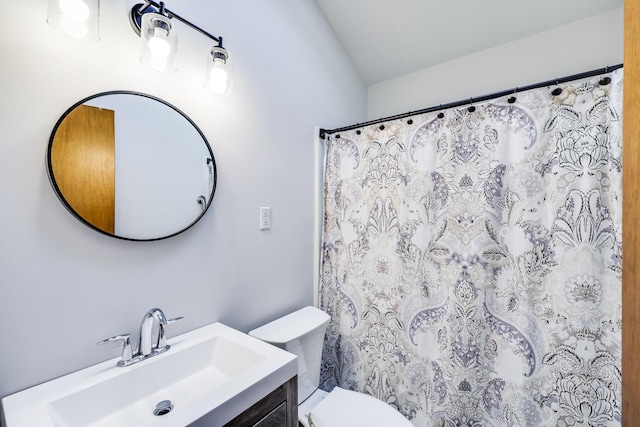 bathroom featuring toilet, walk in shower, and vanity