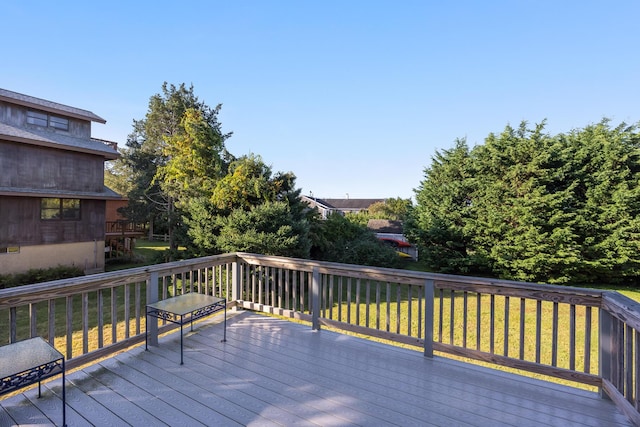 wooden terrace featuring a lawn