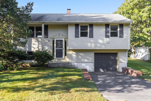 split foyer home with a garage and a front yard