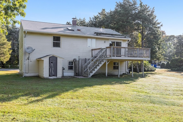 back of house featuring a wooden deck and a yard