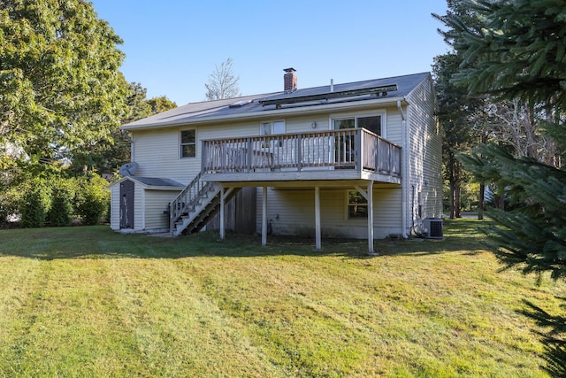 back of property featuring a deck, cooling unit, a yard, and a shed