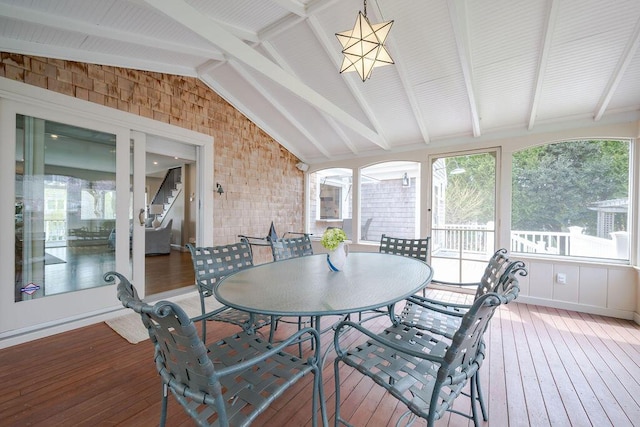 sunroom featuring lofted ceiling with beams and hardwood / wood-style floors