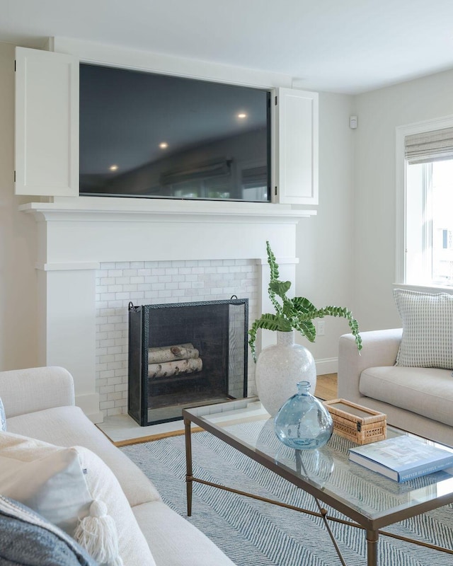 living room featuring baseboards, a fireplace, and light wood-type flooring
