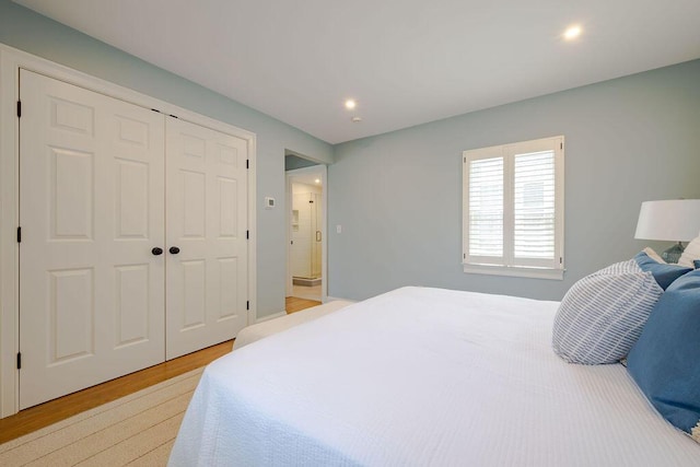 bedroom featuring light wood-type flooring, recessed lighting, and a closet