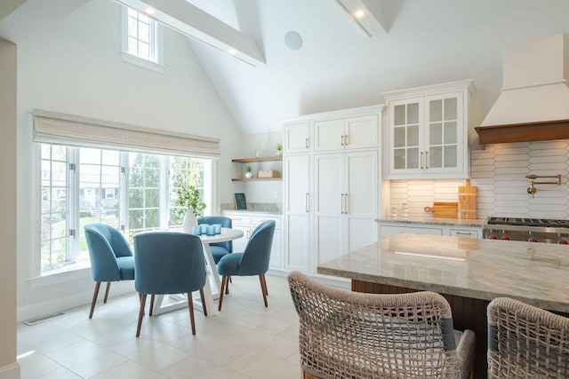 dining room featuring beamed ceiling, high vaulted ceiling, visible vents, and plenty of natural light