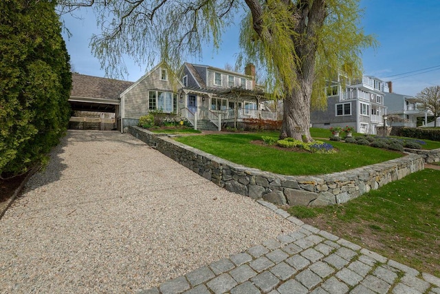 view of front of home featuring a chimney, gravel driveway, and a front yard