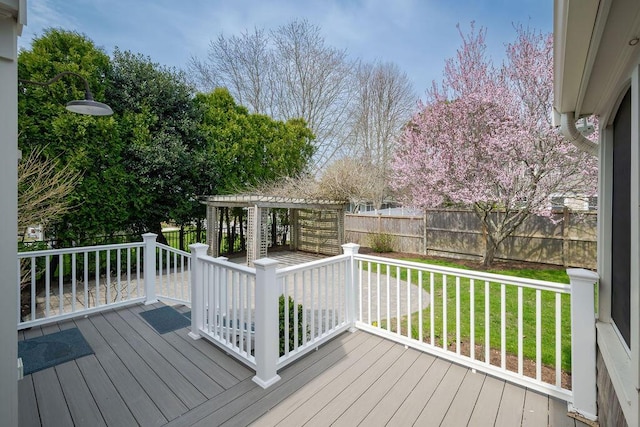 deck featuring a yard, a pergola, and a fenced backyard