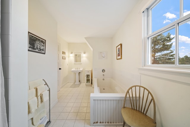 hall with light tile patterned flooring, a healthy amount of sunlight, and sink