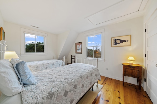 bedroom with multiple windows and light wood-type flooring