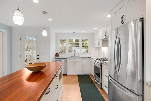 kitchen featuring light wood-type flooring, butcher block countertops, a sink, white cabinetry, and stainless steel appliances