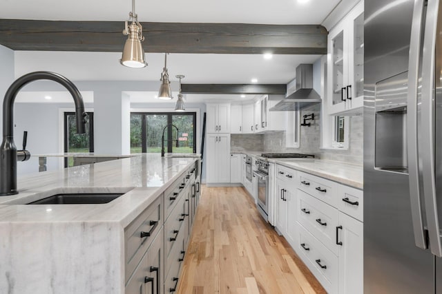 38 Mill St, Dennis Port, MA 02639 - kitchen featuring wall chimney range hood, light wood-style flooring, stainless steel appliances, and a sink