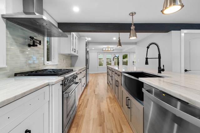38 Mill St, Dennis Port, MA 02639 - kitchen featuring a sink, stainless steel appliances, beamed ceiling, light wood finished floors, and wall chimney exhaust hood