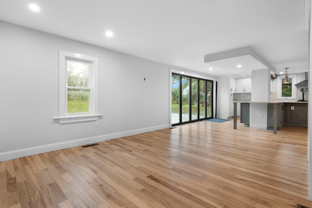 38 Mill St, Dennis Port, MA 02639 - unfurnished living room featuring recessed lighting, baseboards, light wood-style floors, and plenty of natural light