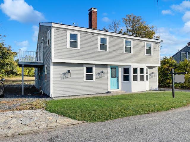 38 Mill St, Dennis Port, MA 02639 - colonial house featuring a wooden deck, a front lawn, and a chimney