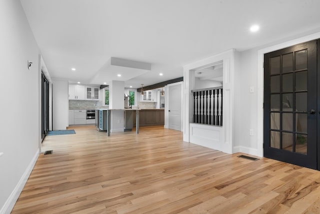 38 Mill St, Dennis Port, MA 02639 - unfurnished living room with a sink, light wood finished floors, baseboards, visible vents, and recessed lighting