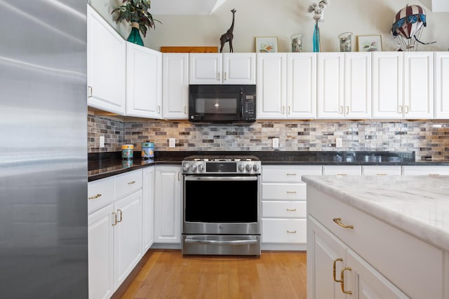 kitchen with white cabinets, light stone counters, and stainless steel appliances