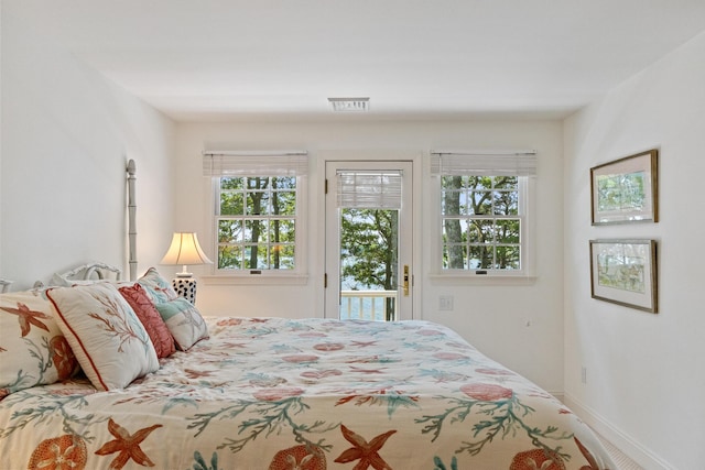 bedroom with access to outside, multiple windows, visible vents, and baseboards