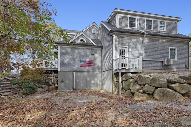 rear view of property featuring a wooden deck and cooling unit