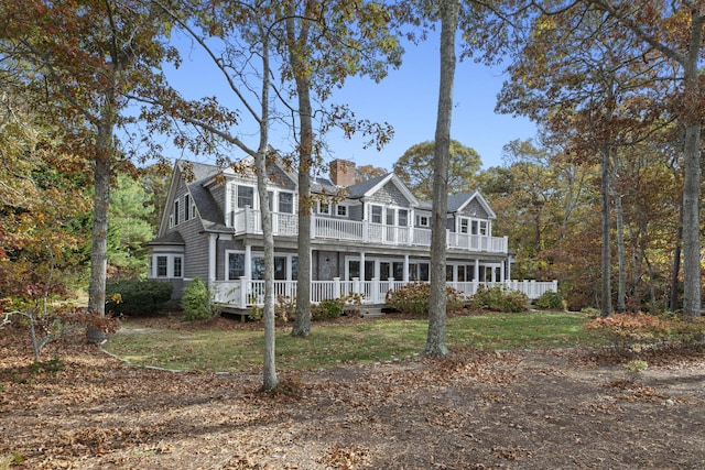 view of front of home featuring a deck, a chimney, and a balcony