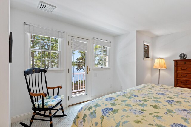 bedroom with light colored carpet, multiple windows, and access to outside