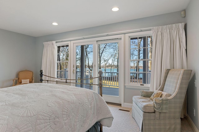 bedroom with a water view, access to exterior, baseboards, and recessed lighting