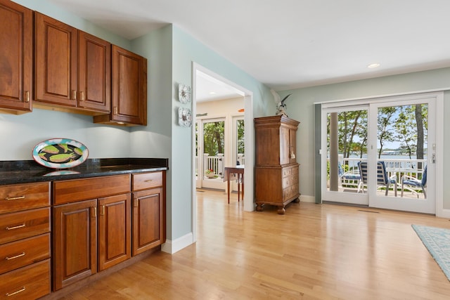 kitchen featuring light hardwood / wood-style floors and dark stone counters