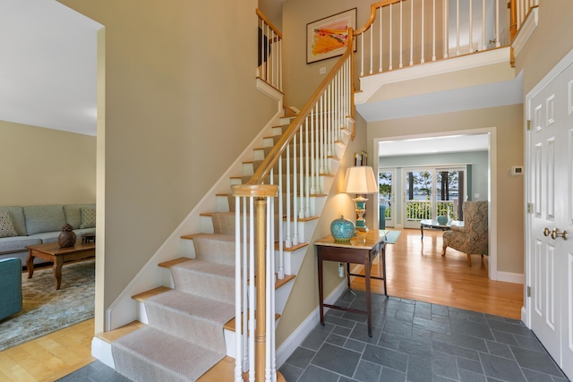 stairs featuring a high ceiling and hardwood / wood-style floors