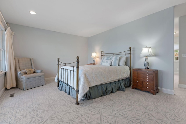 bedroom featuring visible vents, multiple windows, and baseboards