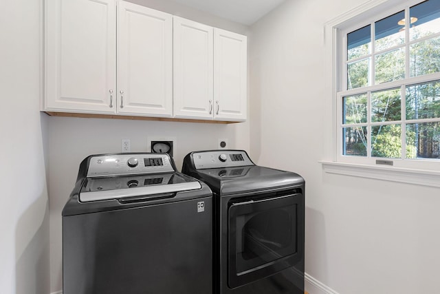 laundry room featuring cabinet space, baseboards, and separate washer and dryer