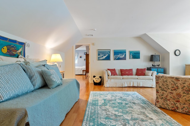 bedroom featuring light wood-type flooring and lofted ceiling