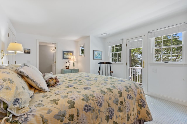 carpeted bedroom with access to exterior, visible vents, and baseboards